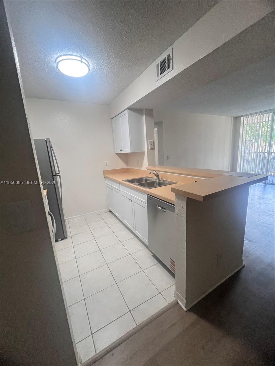 4035 West McNab Road, Unit F206 Pompano Beach, FL 33069 - Photo 13 of 20 a kitchen with stainless steel appliances granite countertop a sink stove and cabinets