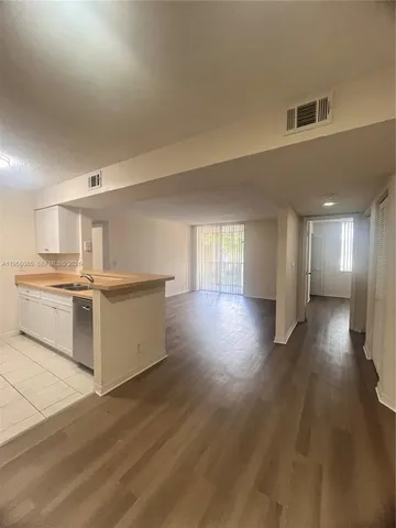 a view of a kitchen with a sink and a refrigerator