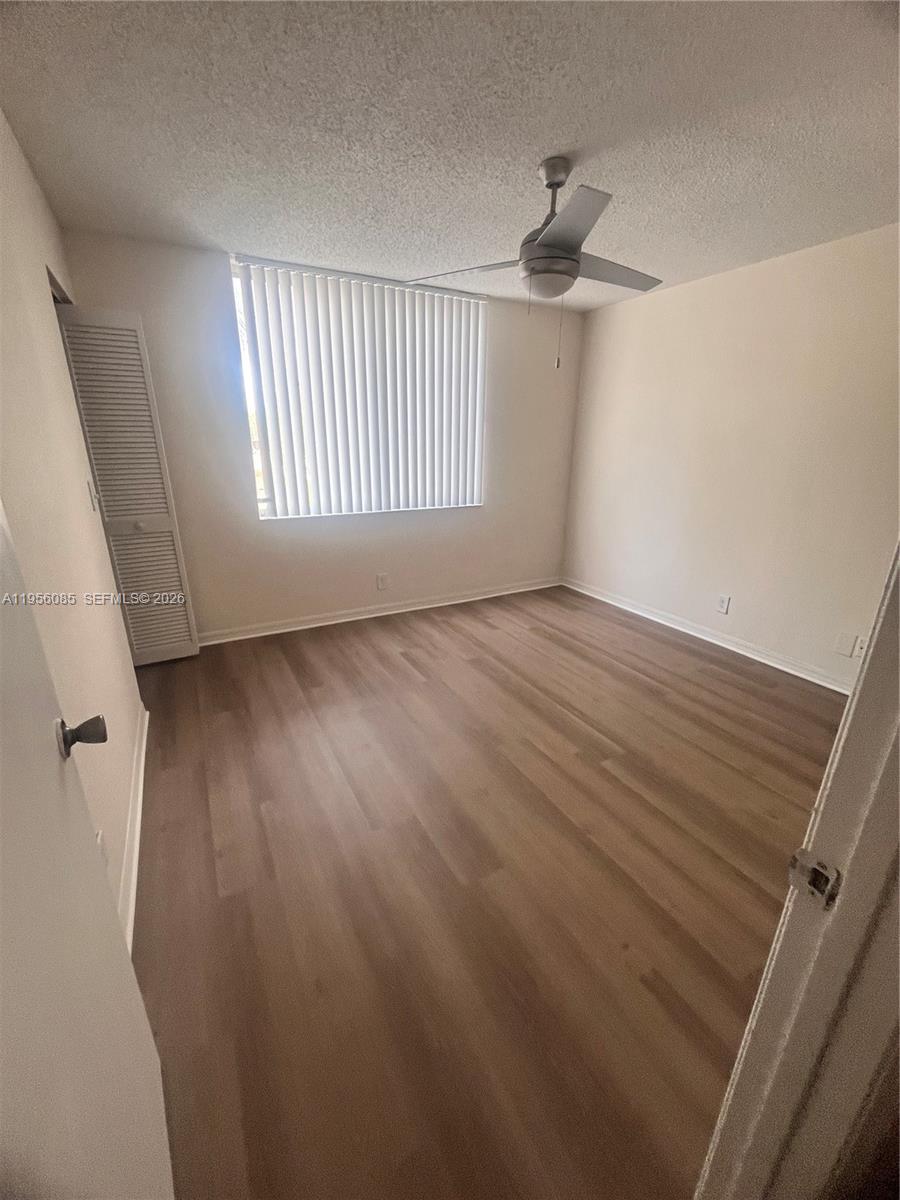 4035 West McNab Road, Unit F206 Pompano Beach, FL 33069 - Photo 4 of 20 wooden floor in an empty room with a window