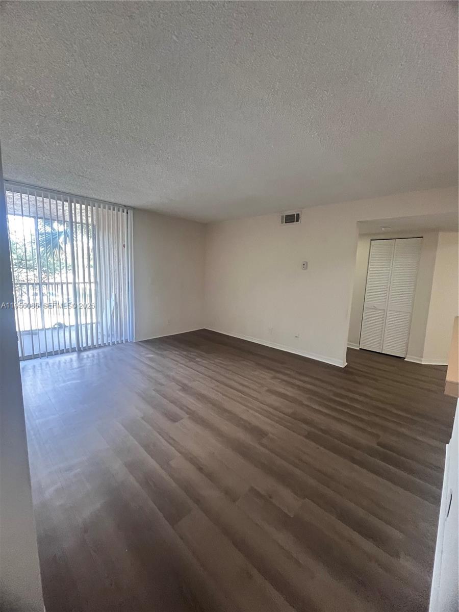 4035 West McNab Road, Unit F206 Pompano Beach, FL 33069 - Photo 9 of 20 a view of an empty room with wooden floor and a window