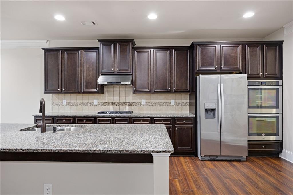 103 Gray Trail Acworth, GA 30101 - Photo 16 of 44 a kitchen with granite countertop stainless steel appliances and wooden cabinets