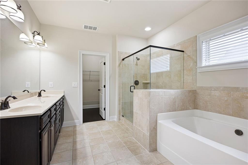 103 Gray Trail Acworth, GA 30101 - Photo 28 of 44 a bathroom with a tub sink and mirror