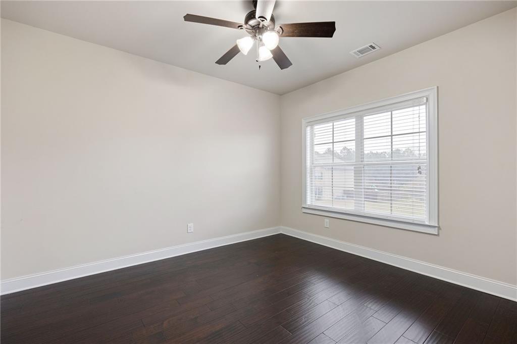 103 Gray Trail Acworth, GA 30101 - Photo 34 of 44 an empty room with wooden floor chandelier fan and windows