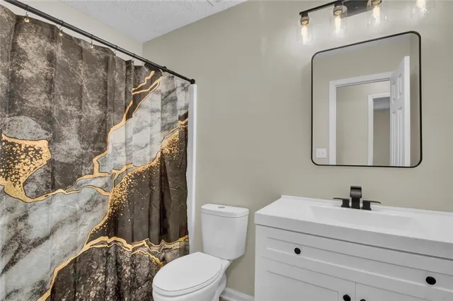 a bathroom with a sink vanity mirror and toilet