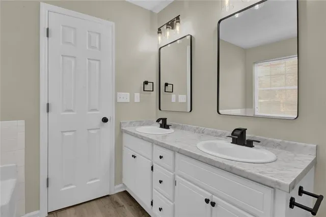 a bathroom with double sink and a mirror