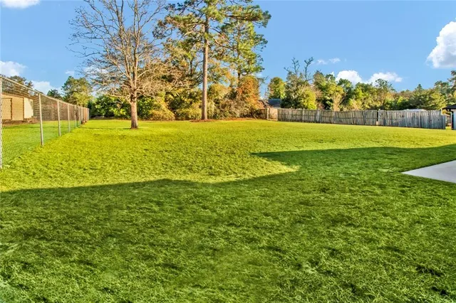 a view of yard with swimming pool and green space