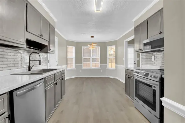 a kitchen with a sink stove and cabinets