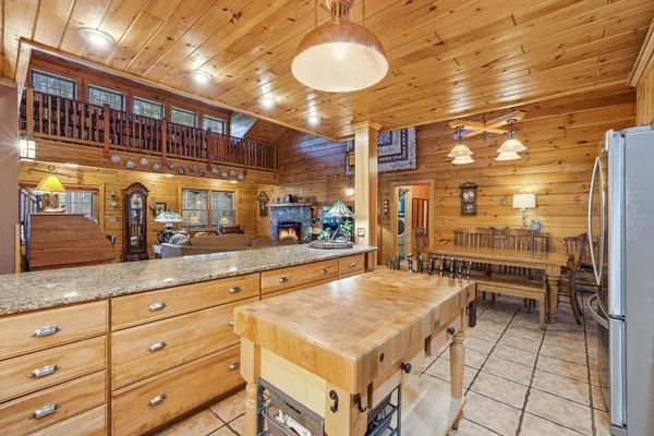 a view of a kitchen with kitchen island granite countertop a large window and a counter space