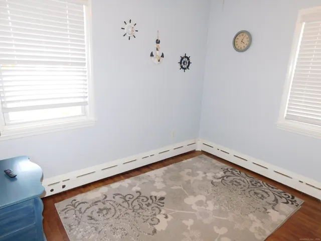 a living room with a flat screen tv on a dresser and a table