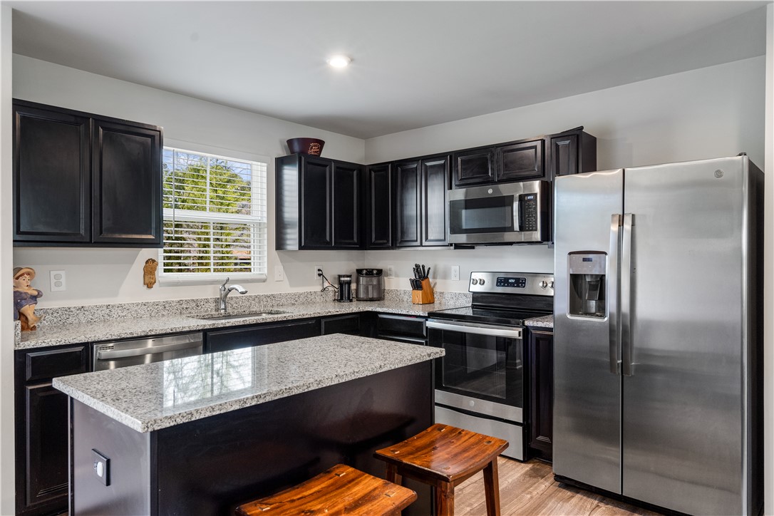 115 Queens Mill Court Pendleton, SC 29670 - Photo 13 of 32 Gleaming stone countertops and dark cabinetry anchor this kitchen space.
