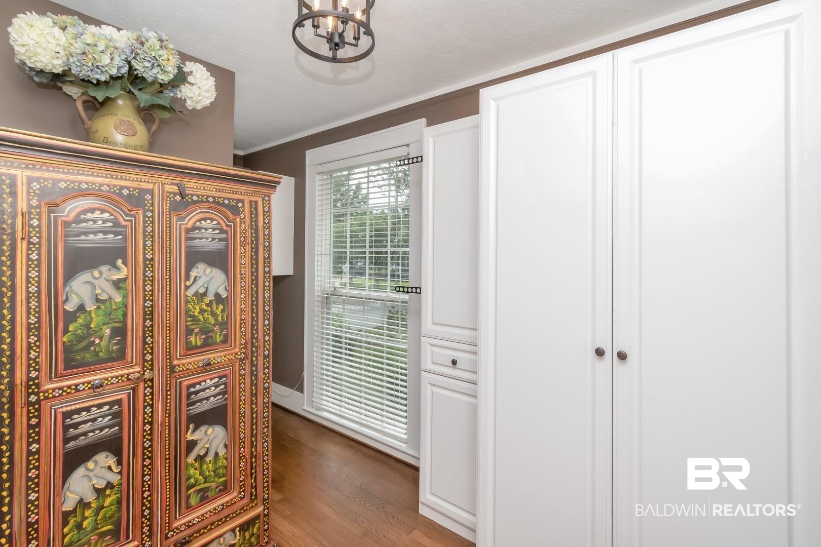 117 South Fulton Street Mobile, AL 36606 - Photo 19 of 34 Hall featuring crown molding, wood-type flooring, and a notable chandelier