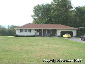 73 Baldwin Road Waymart, PA 18472 - Photo 1 of 6 a front view of a house with a garden