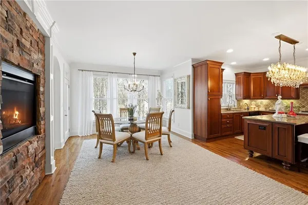 a kitchen with granite countertop a refrigerator a sink dishwasher and wooden cabinets with wooden floor