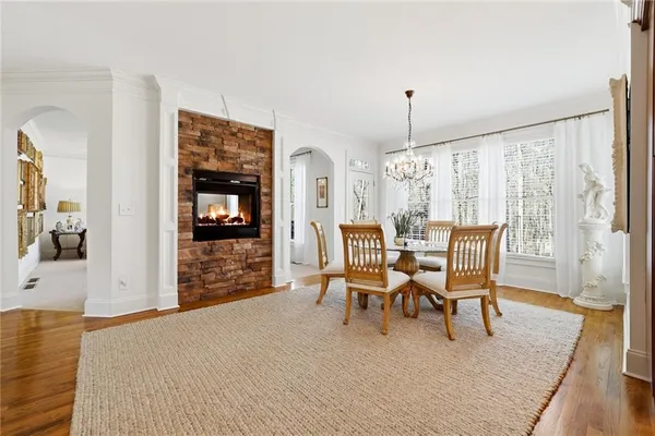 a view of a dining room with furniture a chandelier and wooden floor