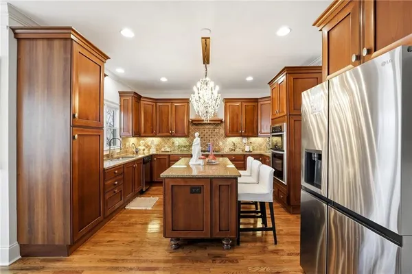 a kitchen with stainless steel appliances granite countertop a refrigerator a stove a sink and a refrigerator