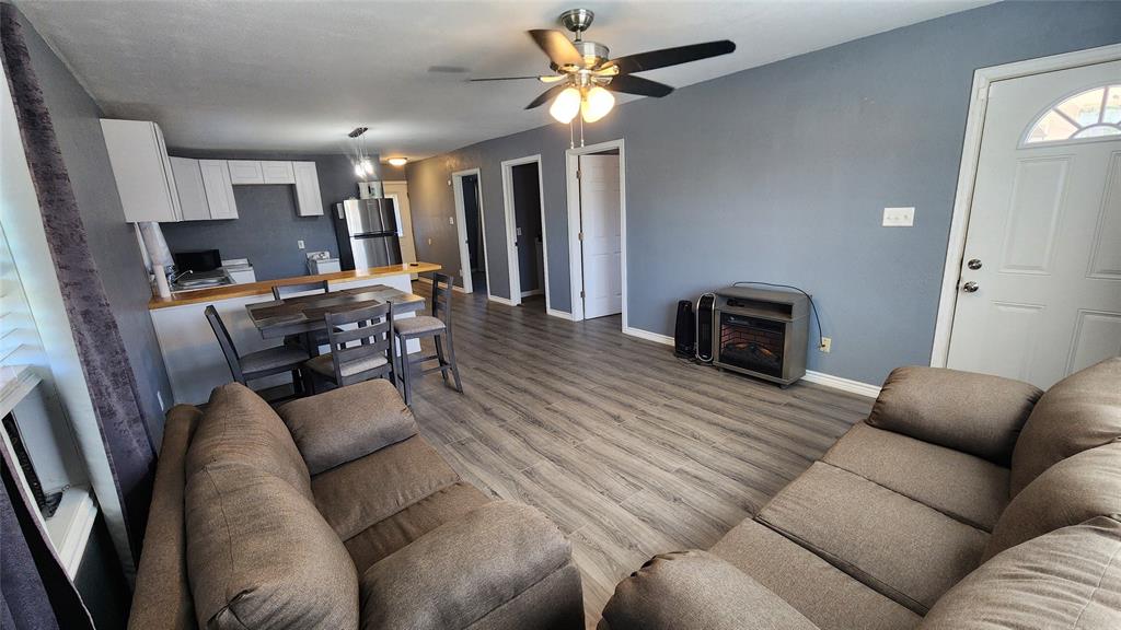 809 Bowie Street Sweetwater, TX 79556 - Photo 2 of 20 Living area featuring baseboards, ceiling fan, and wood finished floors