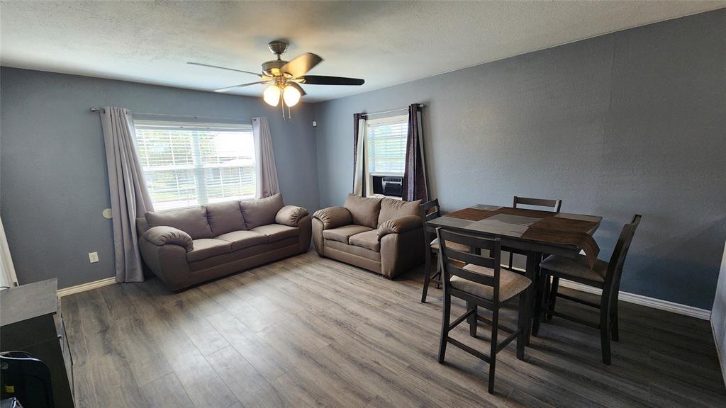 809 Bowie Street Sweetwater, TX 79556 - Photo 3 of 20 Living room with ceiling fan, wood finished floors, baseboards, and cooling unit