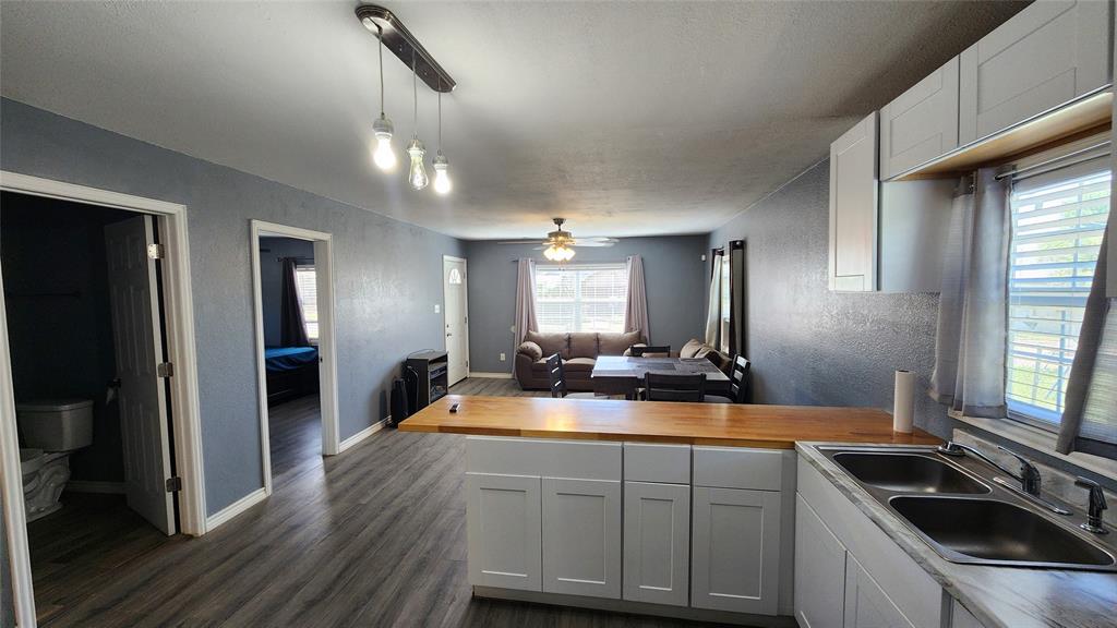809 Bowie Street Sweetwater, TX 79556 - Photo 20 of 20 Kitchen with a sink, wooden counters, open floor plan, dark wood-style flooring, and a peninsula