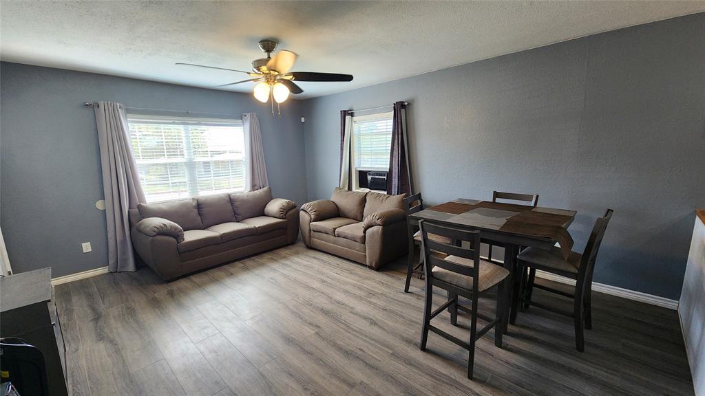 809 Bowie Street Sweetwater, TX 79556 - Photo 4 of 20 Living area featuring a ceiling fan, wood finished floors, and baseboards