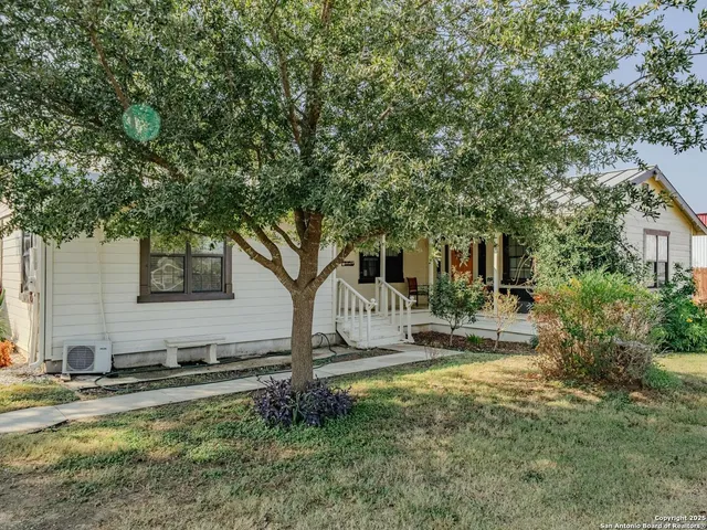 a view of a house with backyard and tree