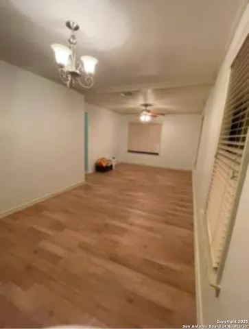 wooden floor in an empty room with a chandelier