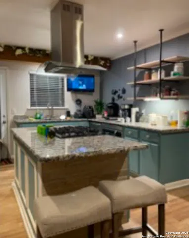 a kitchen with stainless steel appliances granite countertop a stove a sink and a microwave