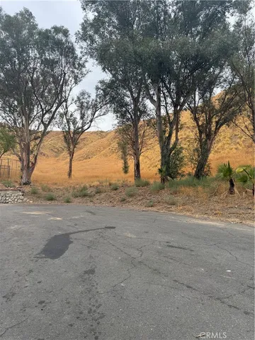 a view of dirt yard with a tree