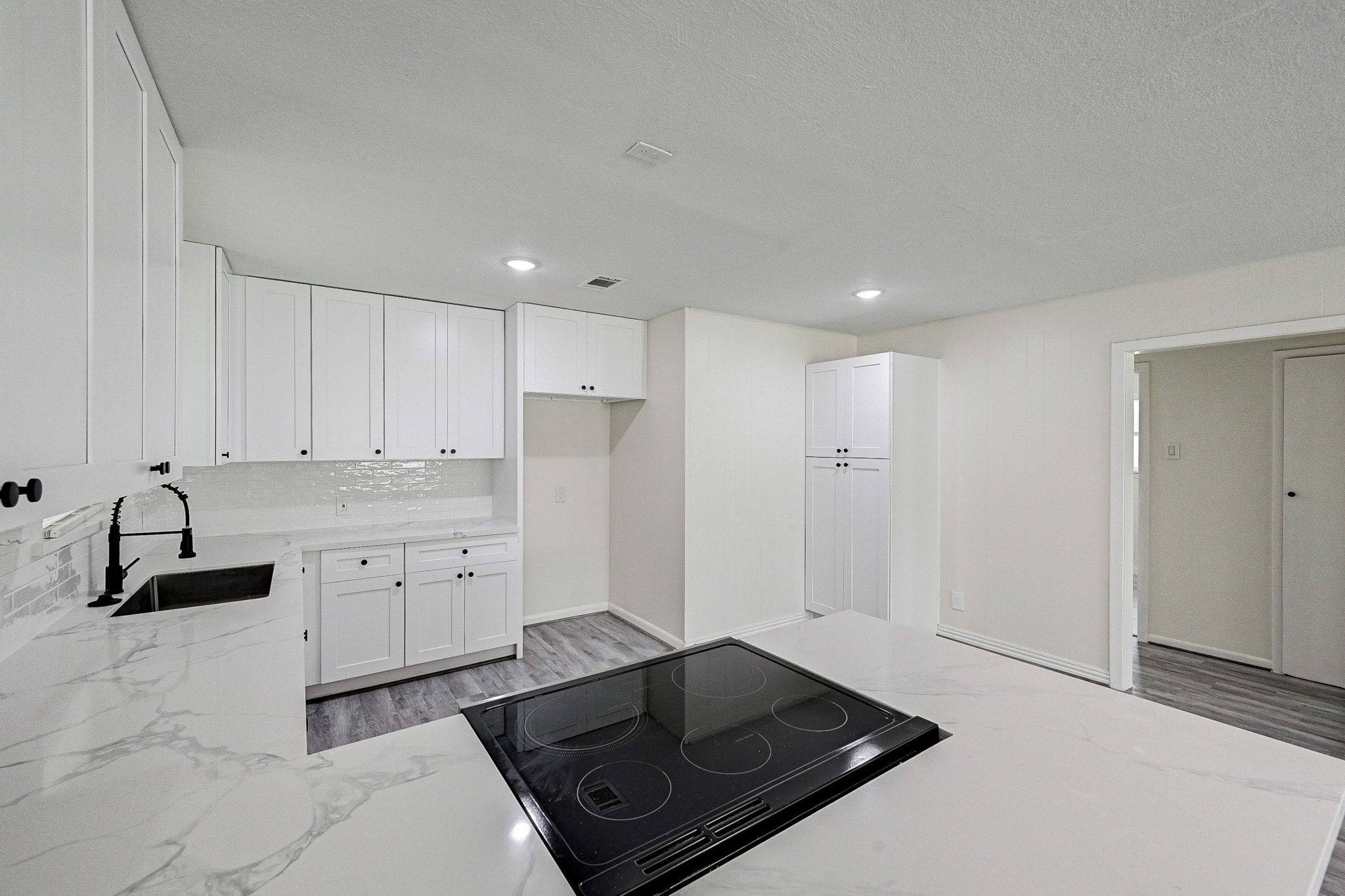 6027 Ledbetter Street Houston, TX 77087 - Photo 8 of 23 a kitchen with granite countertop white cabinets and black appliances