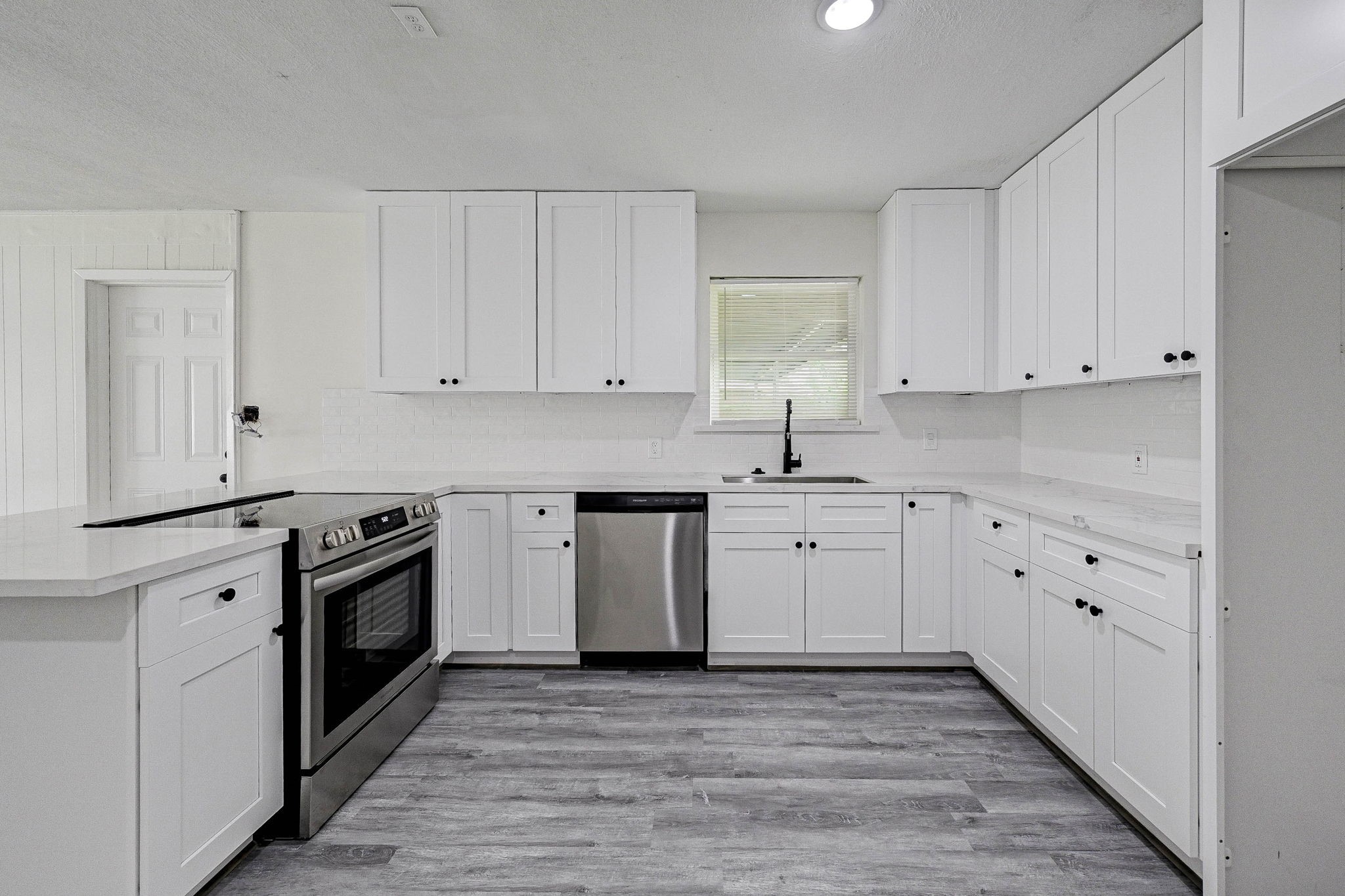 6027 Ledbetter Street Houston, TX 77087 - Photo 10 of 23 a kitchen with granite countertop white cabinets and stainless steel appliances