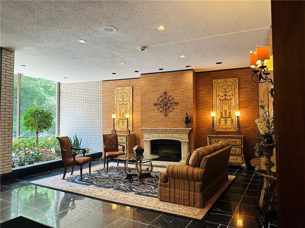 1150 Bower Hill Road, Unit 718B Mt. Lebanon, PA 15243 - Photo 4 of 21 a living room with furniture a fireplace and a floor to ceiling window