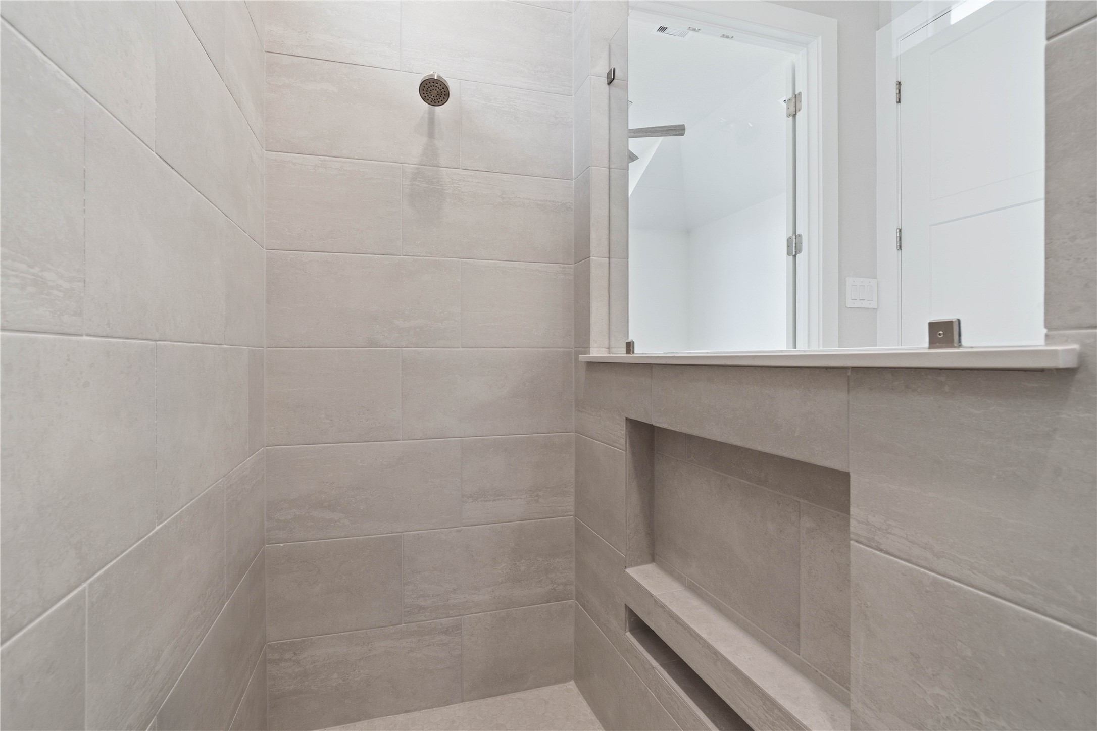 9123 Petroglyph Pt Court Porter, TX 77365 - Photo 31 of 43 Indulge in the spa-like luxury of this primary bathroom, featuring a stunning walk-in shower adorned with tile surround and a sleek showerhead.
