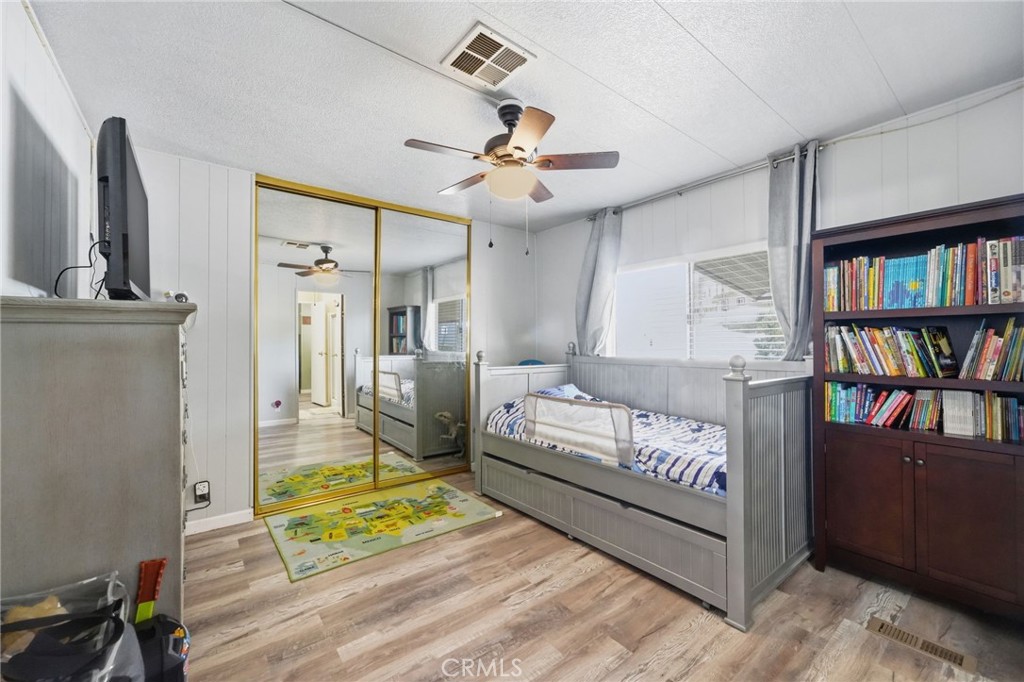 15181 Van Buren Boulevard, Unit 85 Riverside, CA 92504 - Photo 17 of 54 a bedroom with furniture and a book shelf
