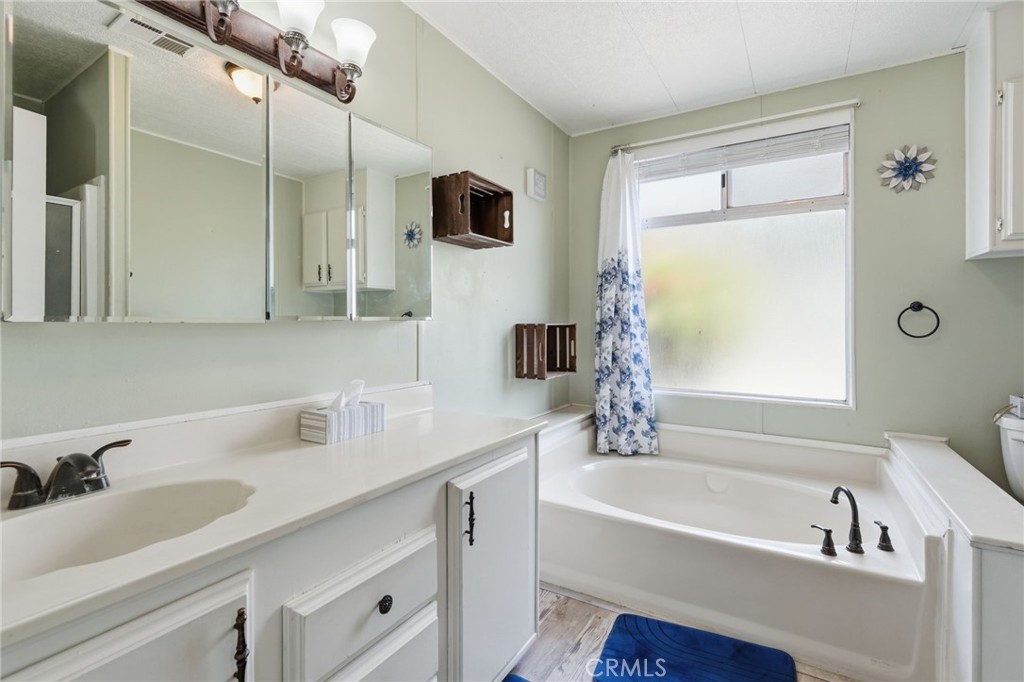 15181 Van Buren Boulevard, Unit 85 Riverside, CA 92504 - Photo 21 of 54 a bathroom with a tub sink and mirror