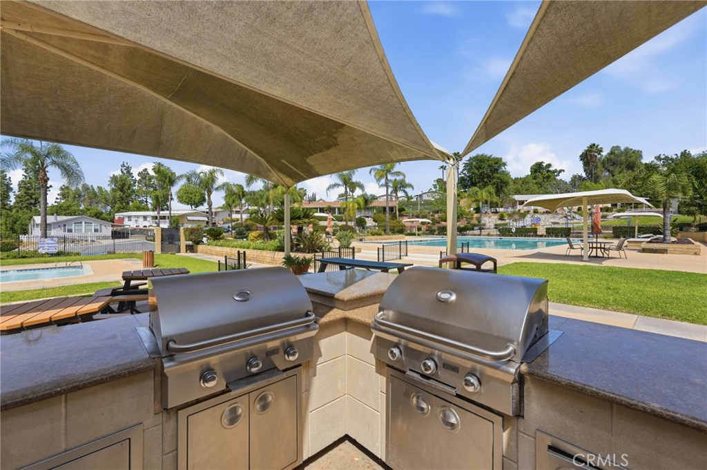 15181 Van Buren Boulevard, Unit 85 Riverside, CA 92504 - Photo 35 of 54 a view of a patio with table and chairs under an umbrella