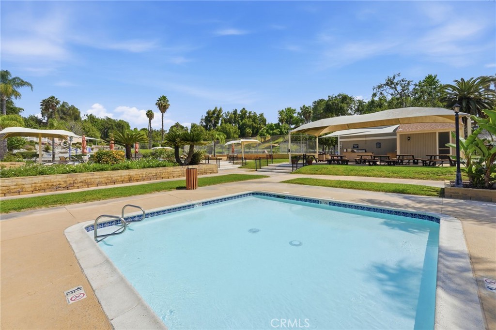15181 Van Buren Boulevard, Unit 85 Riverside, CA 92504 - Photo 42 of 54 a view of swimming pool with outdoor seating and house in the background