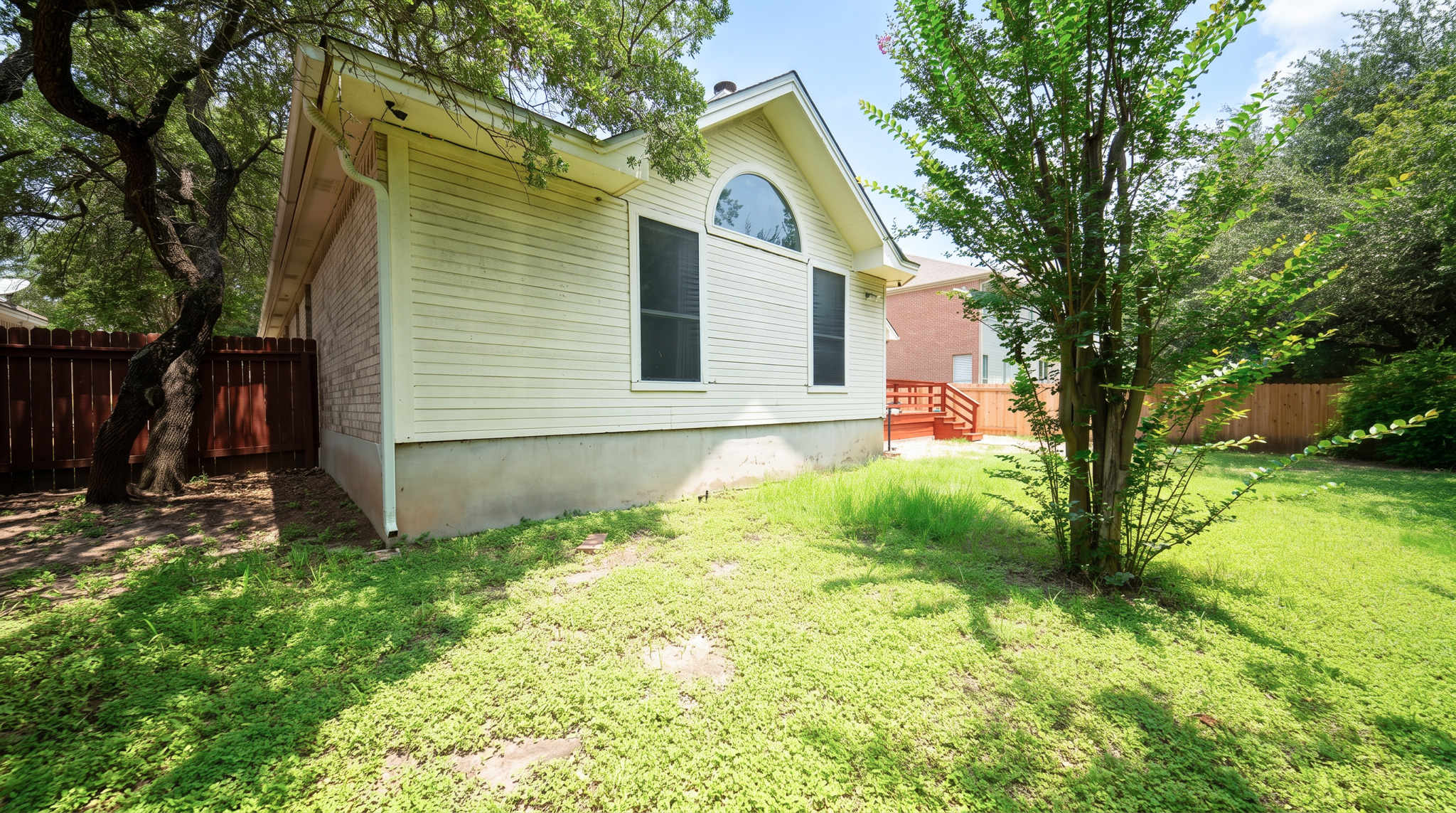 1108 Antelope Ridge Cedar Park, TX 78613 - Photo 21 of 27 A private backyard oasis with mature trees and a charming home with an arched window.