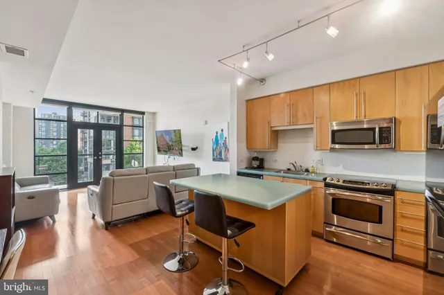 a kitchen with a stove a sink a microwave a dining table and chairs