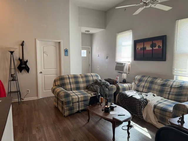 a living room with furniture and wooden floor
