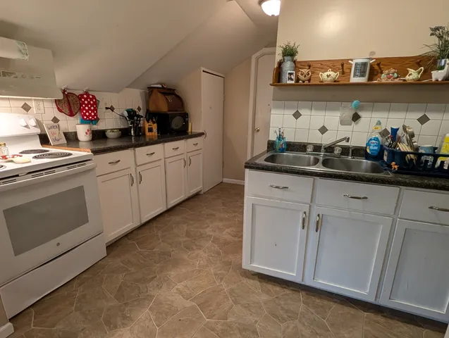 a kitchen with white cabinets and a sink