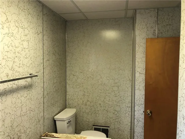 a white toilet sitting next to a shower curtain