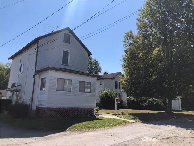 a brick house with tree in front of it