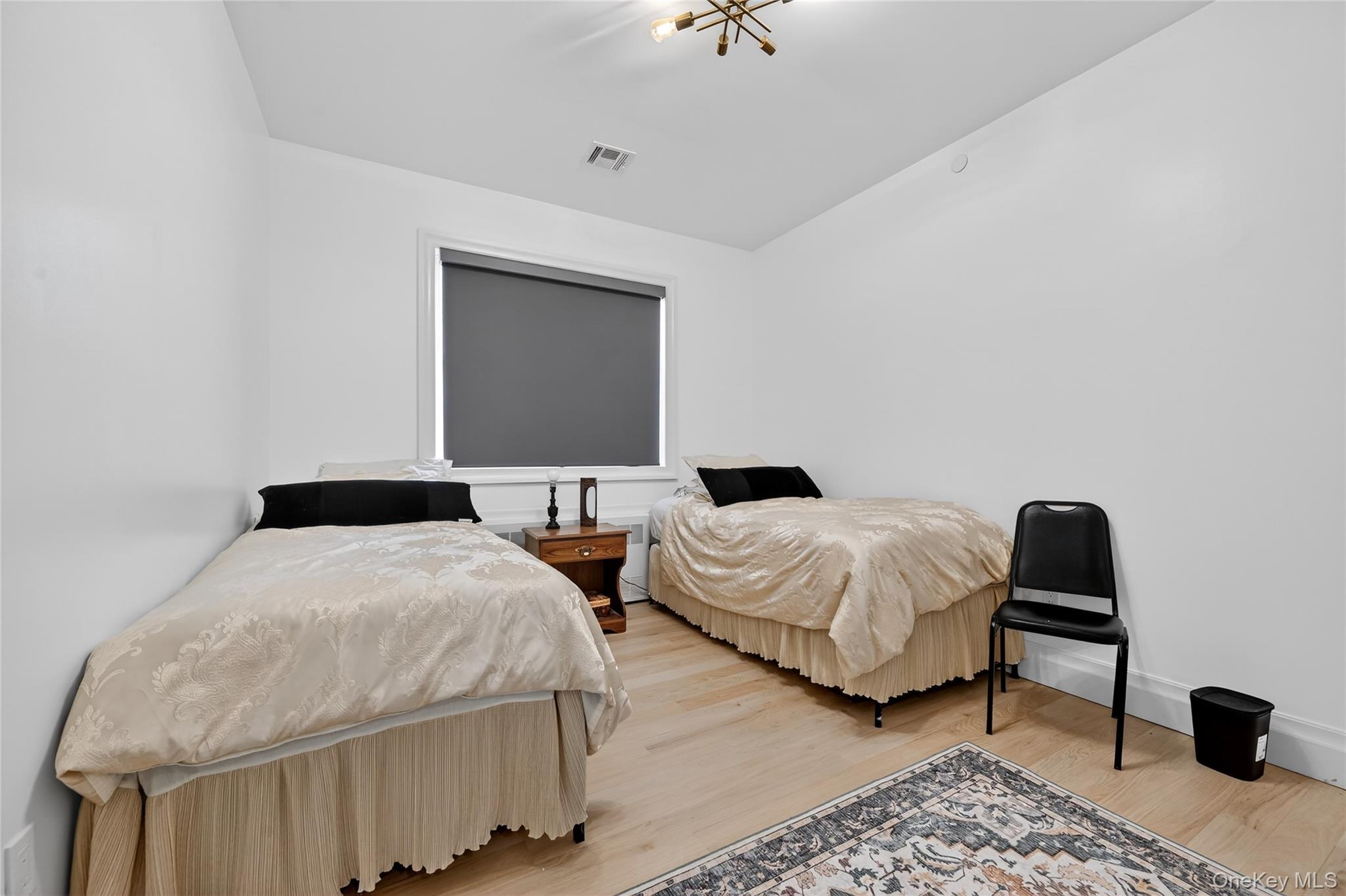27 Ellish Parkway, Unit 203 Spring Valley, NY 10977 - Photo 27 of 47 a bedroom with two beds and a chair