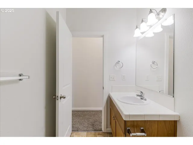 a bedroom with a bed a couch and a chandelier