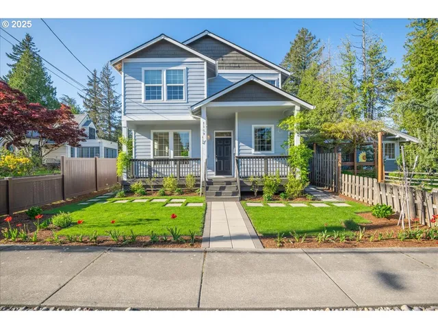 a front view of a house with a yard and potted plants