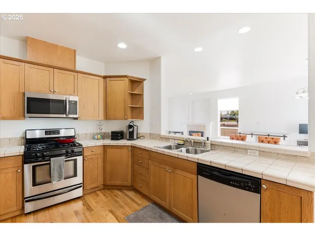 a kitchen with stainless steel appliances a sink stove microwave and cabinets