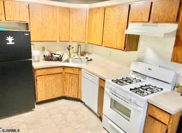 a kitchen with a sink a stove and cabinets