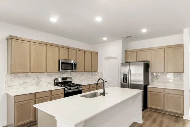a view of a kitchen with stove and wooden floor