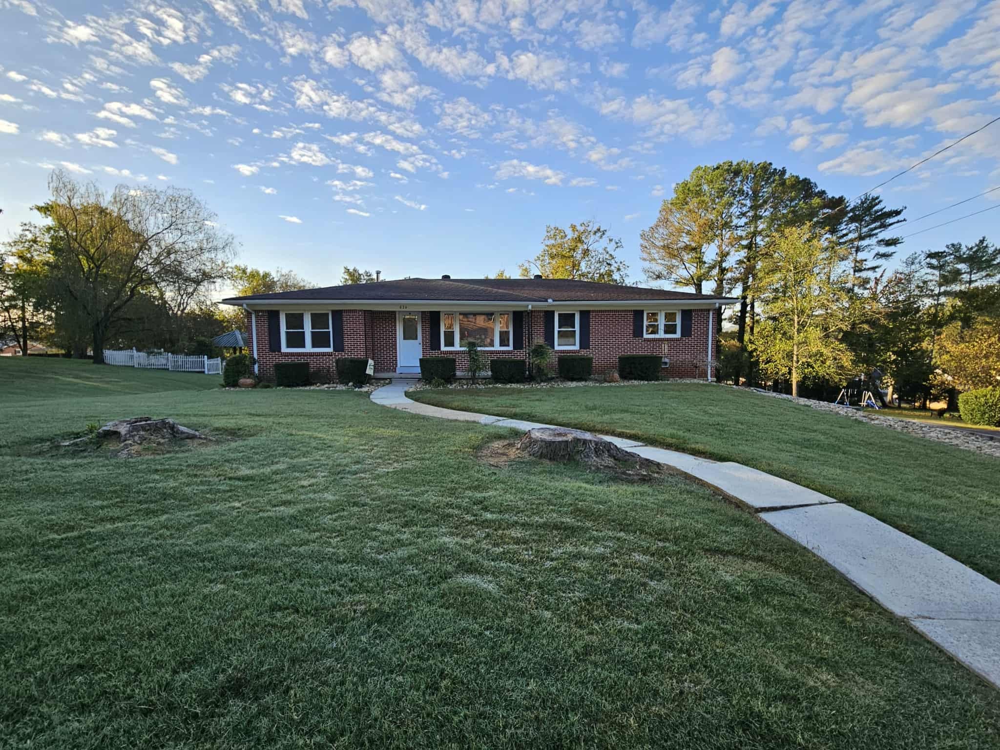 a front view of a house with a garden and trees