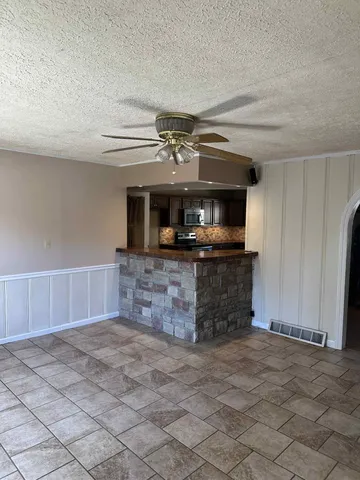 an empty room with a fireplace and a chandelier