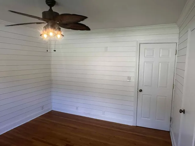a view of empty room with wooden floor